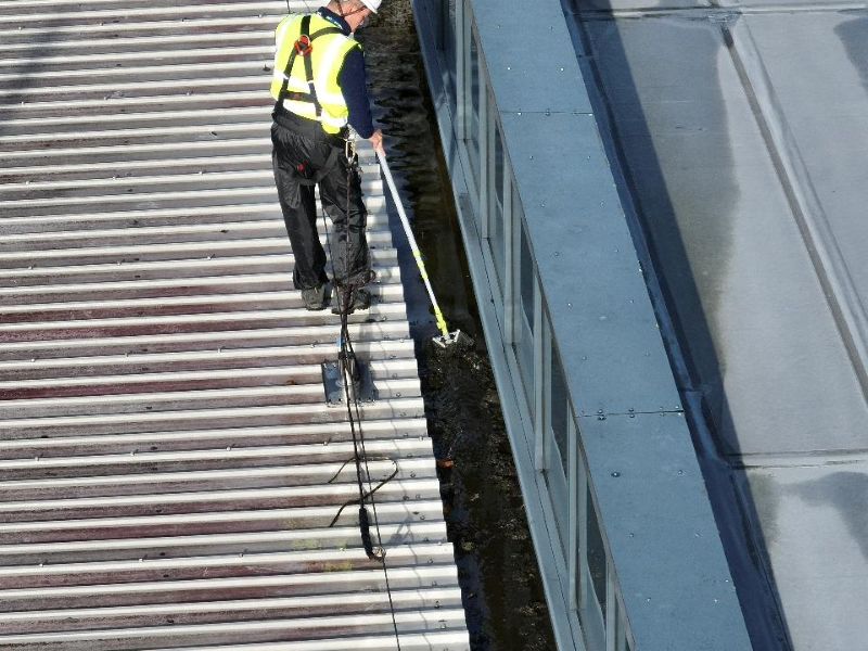 Operative on the roof clearing a water channel channel